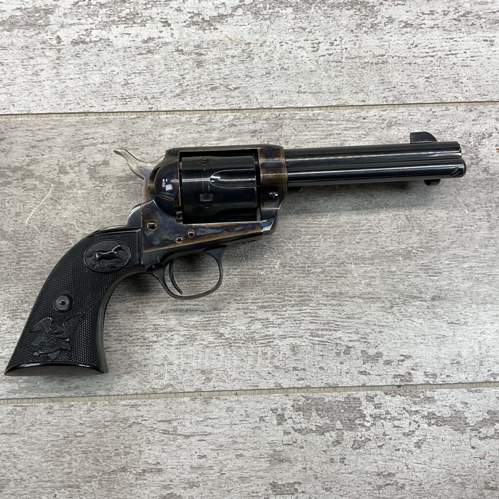 Revolver handgun with a dark finish and engraved details, placed on a wooden surface. Iconic accessory linked to historical themes and classic firearm design.