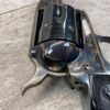 Shiny silver revolver with a reflective surface, close-up view, highlighting the gun's detailed craftsmanship and metallic features.