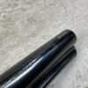 Sharpened black fountain pen tip on textured surface, close-up view with glossy finish and subtle reflections, illustrating fine writing instrument detail and craftsmanship.
