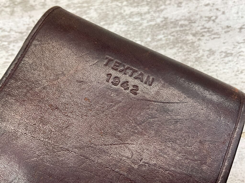 Vintage leather wallet with embossed "Texan 1942" indicating its historical significance and classic style. Perfect for vintage collectors and fashion enthusiasts interested in WWII era accessories.