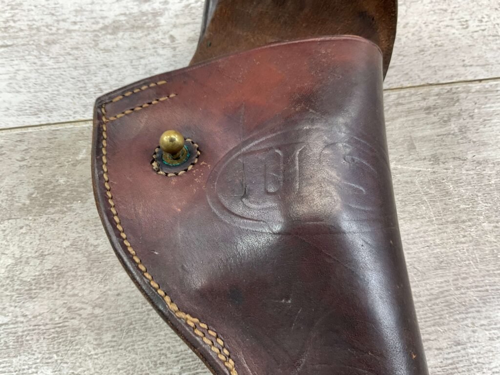 Vintage leather holster with embossed Checkpoint Charlie emblem, historical Berlin military artifact, showcasing Berlin Wall history and Cold War era memorabilia.