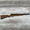 Model air rifle with wooden stock and metal barrel, displayed on a rustic wooden surface. Perfect for collectors or enthusiasts interested in historical or replica firearms.