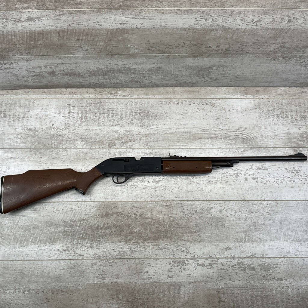 Ammunition rifle on a wooden surface at Checkpoint Charlie, Berlin, showcasing Cold War history and firearm display.