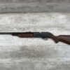 Vintage air rifle with wooden stock on light wooden background.