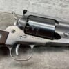 Four-barrel revolver, stainless steel handgun with wooden grip on a rustic wooden surface.